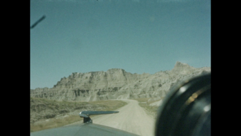 1940s: Car driving on long and winding road near desert cliffs ...