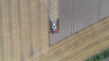 A drone shot of a combine harvester in a field in Barton A drone shot of a combine harvester in a field in Barton