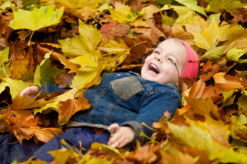 a little child playing in the leaves a little child playing in the leaves