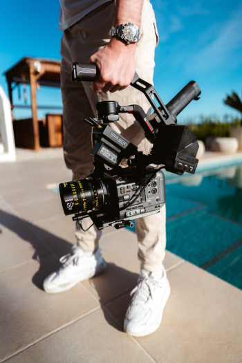 a man standing next to a pool holding a camera a man standing next to a pool holding a camera