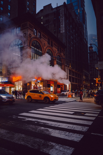 A New York City taxi at a crosswalk in a foggy NYC moment. A New York City taxi at a crosswalk in a foggy NYC moment.