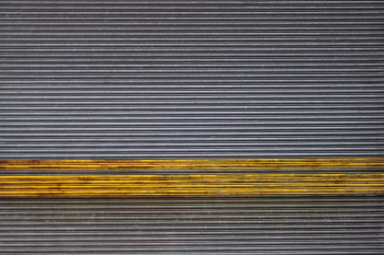 A striking industrial roller shutter door at a now demolished paper mill. The strong horizontal lines and bold yellow stripe of the grungy metal door was just too interesting for me not to capture.