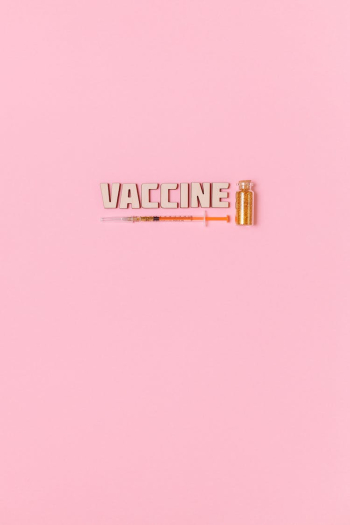 A Syringe and Vaccine Text on Pink Background A Syringe and Vaccine Text on Pink Background