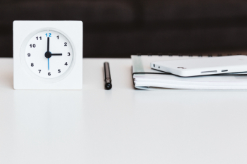 A table clock, a planner and a phone