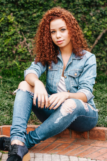 A woman with curly hair seated A woman with curly hair seated