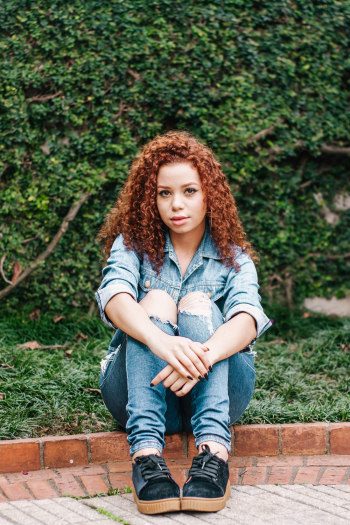a woman with curly hair sitting down a woman with curly hair sitting down