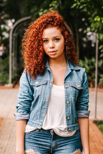 A woman with curly hair wearing denim A woman with curly hair wearing denim