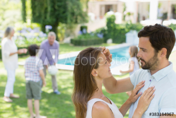 Affectionate couple in backyard with family Affectionate couple in backyard with family