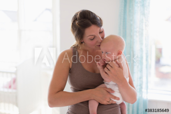 Affectionate mother holding and kissing baby son Affectionate mother holding and kissing baby son
