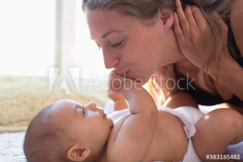 Affectionate mother kissing baby son