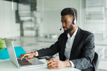 African american man customer support operator with hands-free headset working in the office. Free Photo