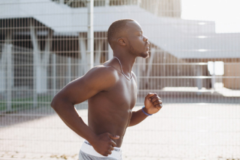 African American man runs along the street African American man runs along the street