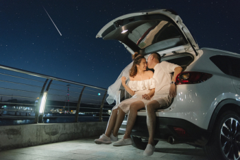 Asian couple sitting behind the car Asian couple sitting behind the car
