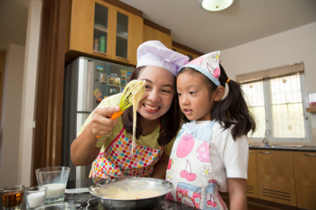 Asian family enjoy making pancake, Asian mom teaching daughter to learn making pancake in real life kitchen at home