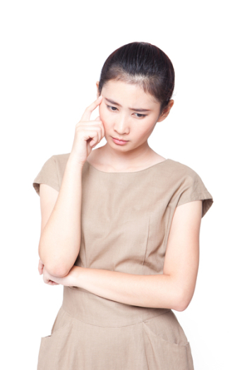 Asian woman looking down and thinking