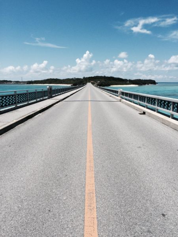 asphalt road near mountain under blue and white cloudy sky asphalt road near mountain under blue and white cloudy sky