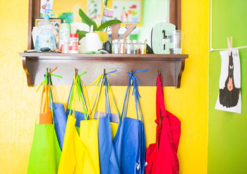 assorted-color bag lot hanging on brown wooden wall rack assorted-color bag lot hanging on brown wooden wall rack