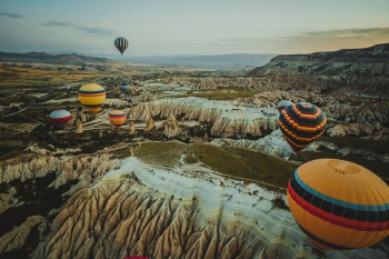 assorted-color hot air balloons on mid-air during orange sunset assorted-color hot air balloons on mid-air during orange sunset