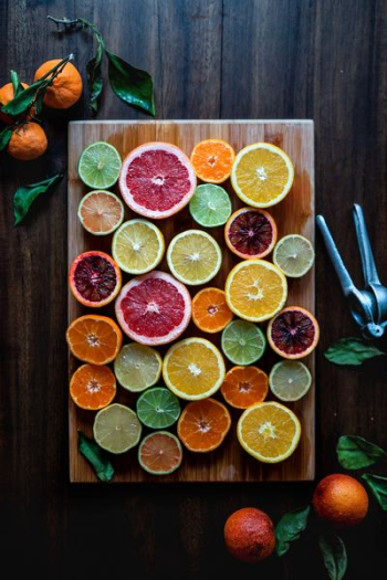 assorted sliced citrus fruits on brown wooden chopping board assorted sliced citrus fruits on brown wooden chopping board
