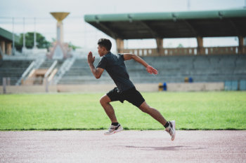 Athlete standing on an all-weather running track Free Photo