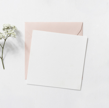 Baby's-breath flowers and pink and white envelope on white background