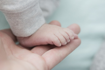 Baby Wearing Gray Bottoms on Person Hand Baby Wearing Gray Bottoms on Person Hand
