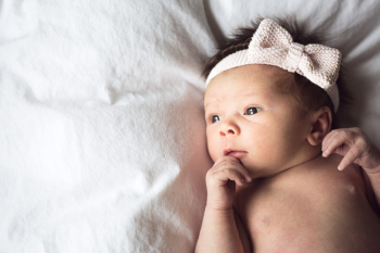 Baby Wearing White Fabric Headband With Bow Accent Baby Wearing White Fabric Headband With Bow Accent