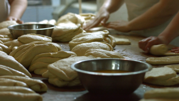 Bakers made bread. Women knead the dough on the table ...