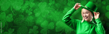 Banner with St. Patrick's Day leprechaun model girl on green magic background with shamrock leaves.