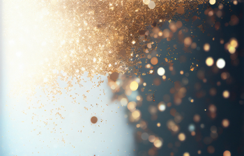 Beautiful Christmas light background. Abstract glitter bokeh and scattered sparkles in gold