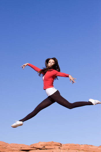 Beautiful young athletic woman jumping high