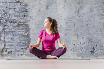 Beautiful young woman sitting in yoga position meditating Beautiful young woman sitting in yoga position meditating
