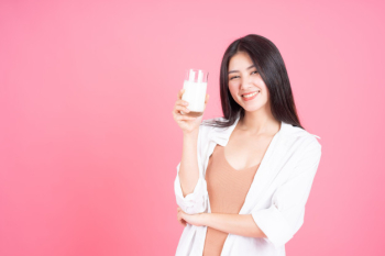 Beauty woman asian cute girl feel happy drinking milk for good health in the morning on pink background Free Photo