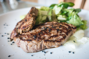 Beef steak with green salad close up Beef steak with green salad close up