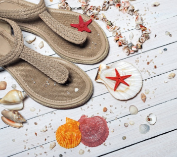 Beige Thong Flat Sandals Placed Beside Seashells