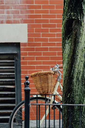 bicycle with woven basket parked beside the street bicycle with woven basket parked beside the street