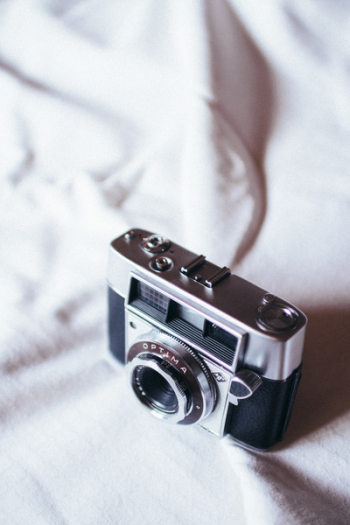 Black And Grey Camera On White Cloth Black And Grey Camera On White Cloth
