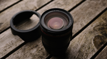 Black Dslr Camera Lens With Lid on Wooden Platform Black Dslr Camera Lens With Lid on Wooden Platform