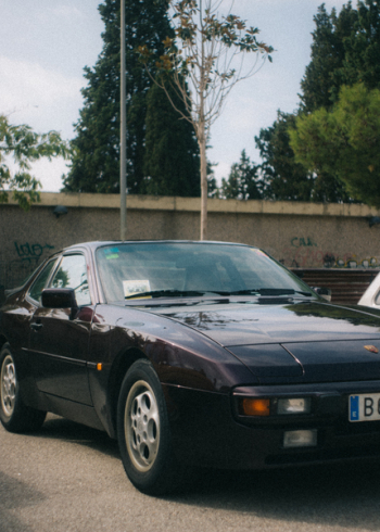 Black Porsche Coupe Near Concrete Wall and Trees Black Porsche Coupe Near Concrete Wall and Trees