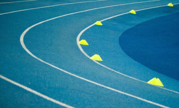 blue curved track field at daytime blue curved track field at daytime