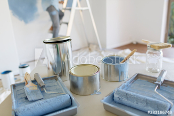 Blue paint cans paintbrushes and rollers in tray Blue paint cans paintbrushes and rollers in tray