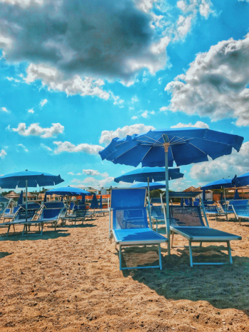 Blue Parasols And Sun Loungers On Sand Blue Parasols And Sun Loungers On Sand