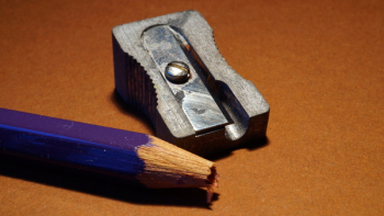 Blue Pencil Beside Gray Sharpener on Brown Surface Blue Pencil Beside Gray Sharpener on Brown Surface