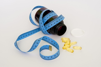 Blue Tape Measure Wrapping Black Medication Pill Bottle With White Cap