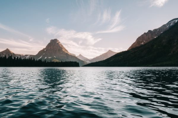 body of water near body trees and mountain body of water near body trees and mountain