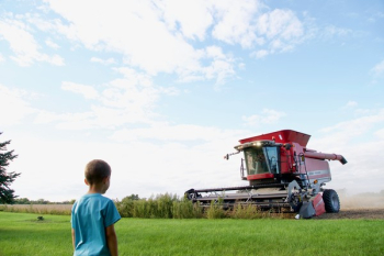 Boy Nears Red Harvester Machine Boy Nears Red Harvester Machine