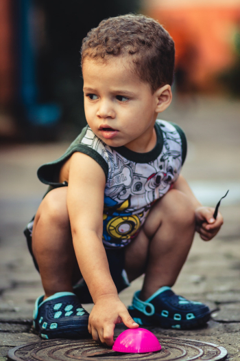Boy Sitting Holding Pink Toy