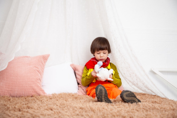 Boy Sitting On Bed