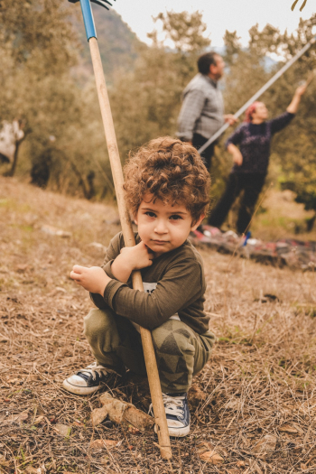 Boy Sitting On Brown Grass