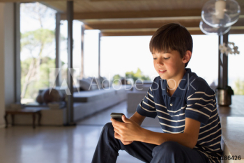 Boy using smart phone at home Boy using smart phone at home
